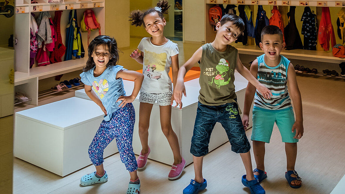 Daylight promotes development and strengthens children's feelings of happiness Happy children laugh and dance in the kindergarten flooded with daylight | insights by LAMILUX