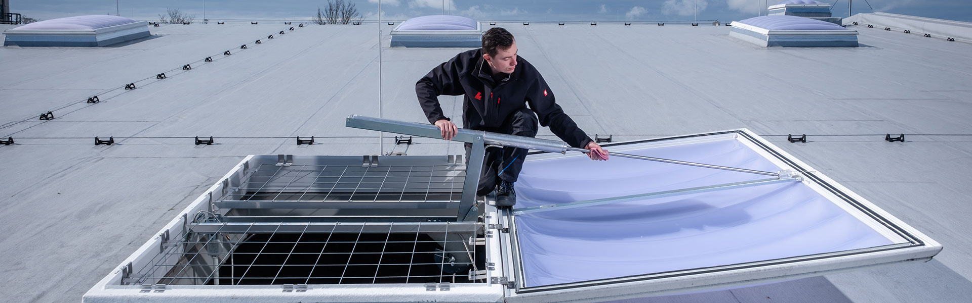 Zwei Monteuere bei der Wartung einer Lichtkuppel auf einer Produktionshalle | insights by LAMILUX