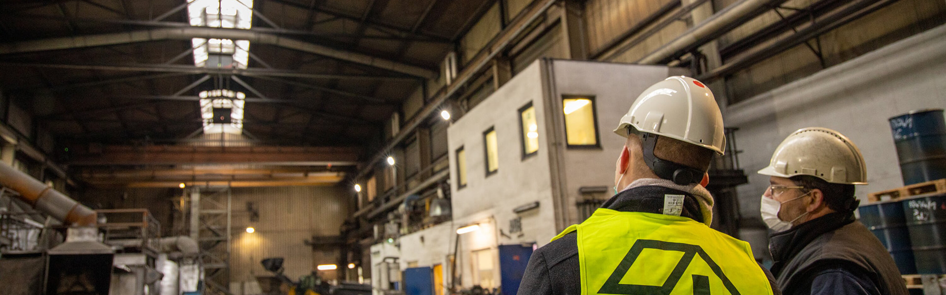 Zwei Sanierungsspezialisten planen in einer Industriehalle die Dachsanierung | insights by LAMILUX