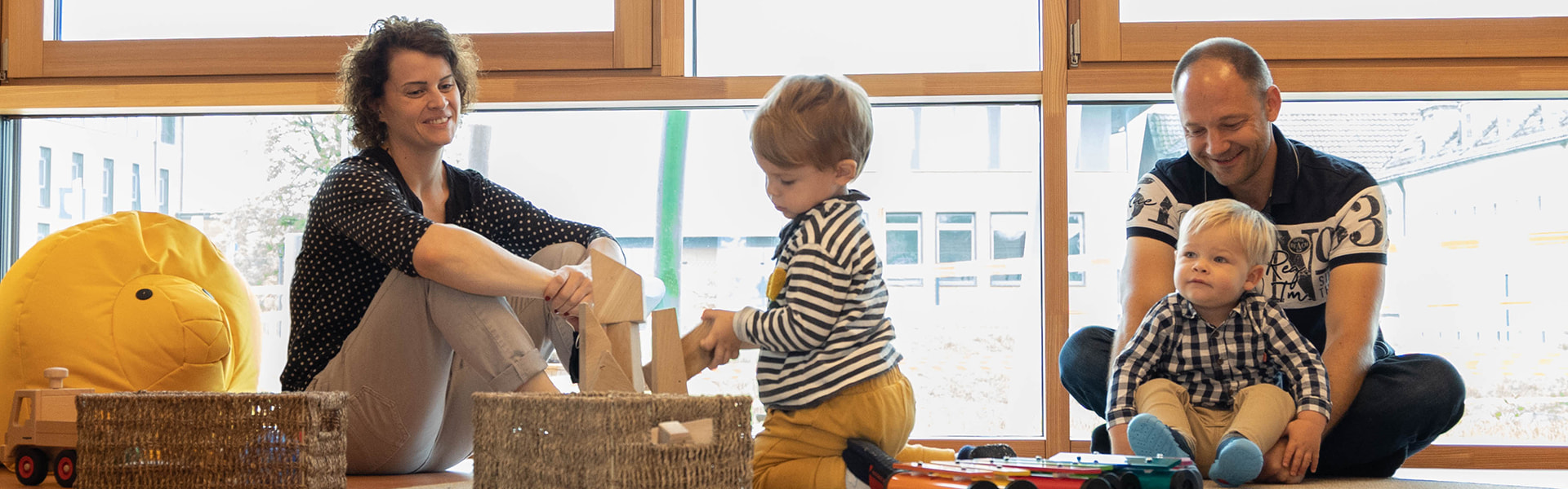 Eltern und Kinder in Kita-Raum mit viel Tageslicht | insights by LAMILUX