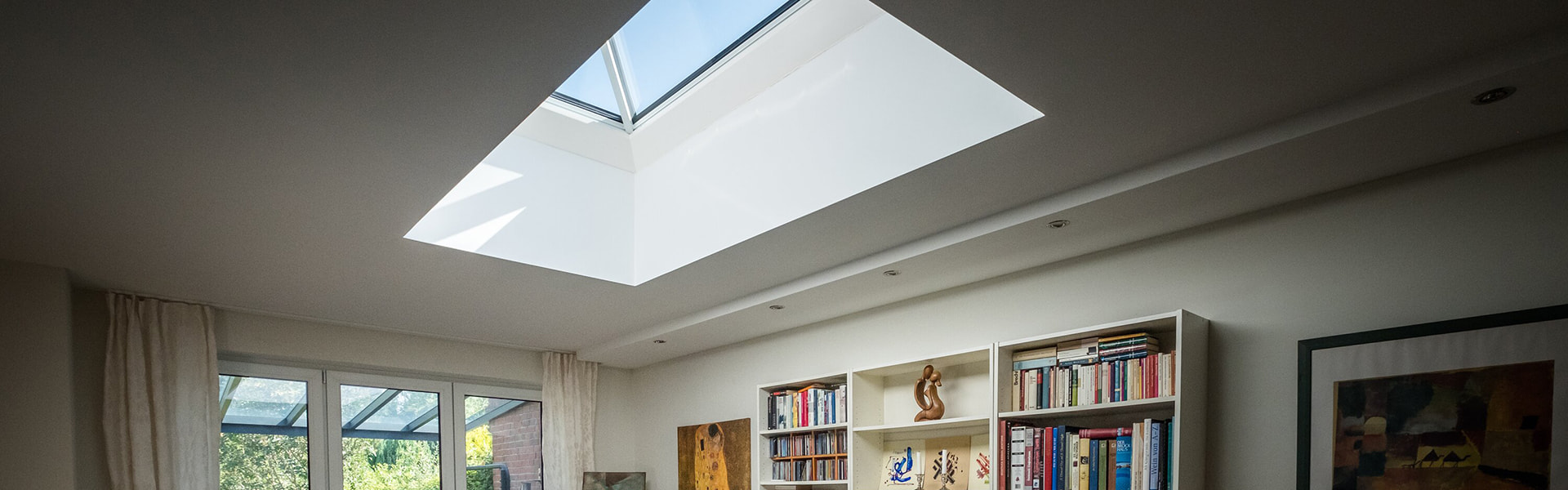 Dining area in a residential building in Hamburg with LAMILUX FW flat roof window, which creates a bright and open atmosphere.