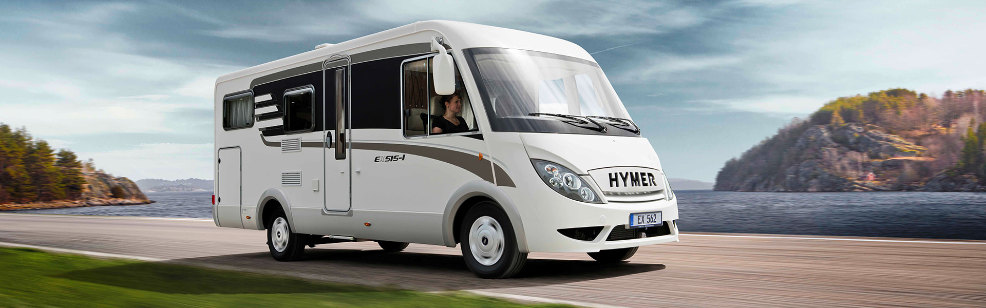 Wohnmobil auf der Straße vor einem See | insights by LAMILUX