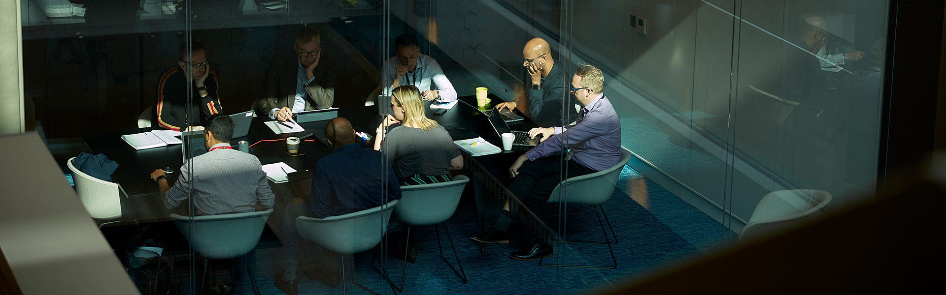 Business meeting in a conference room behind glass walls