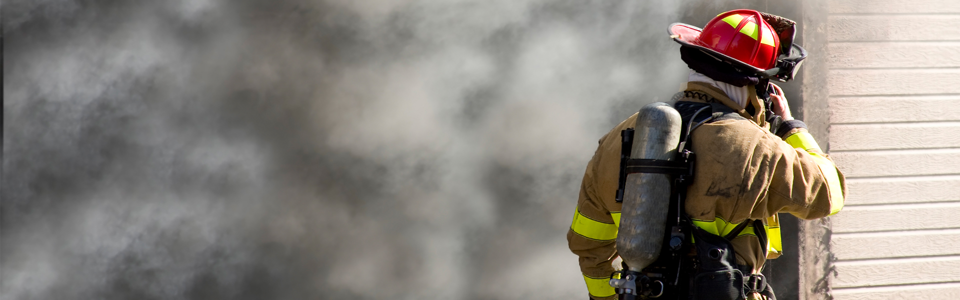 Feuerwehrmann steht vor brennenden Haus | insights by LAMILUX
