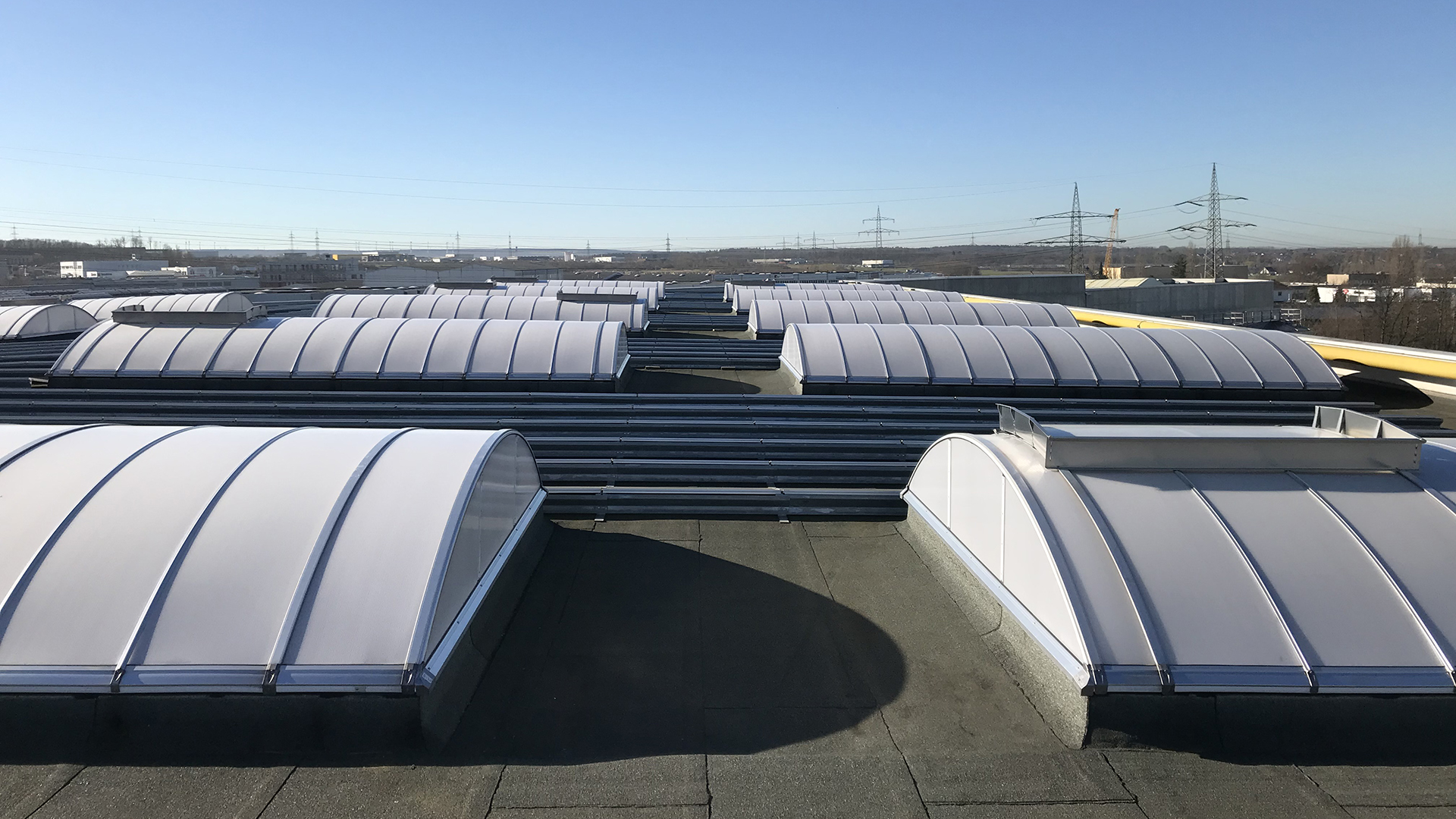 Roof of food manufacturer STUTE in Paderborn with multiple curved skylights for natural lighting.