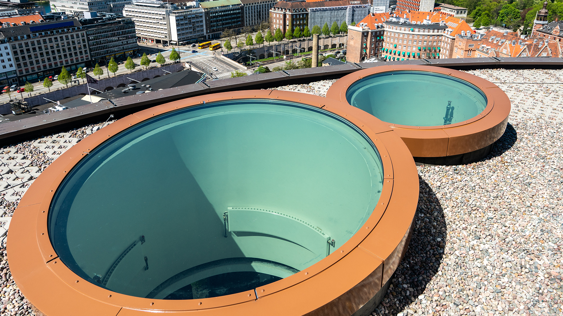 Two circular skylights on modern building roof overlooking urban surroundings