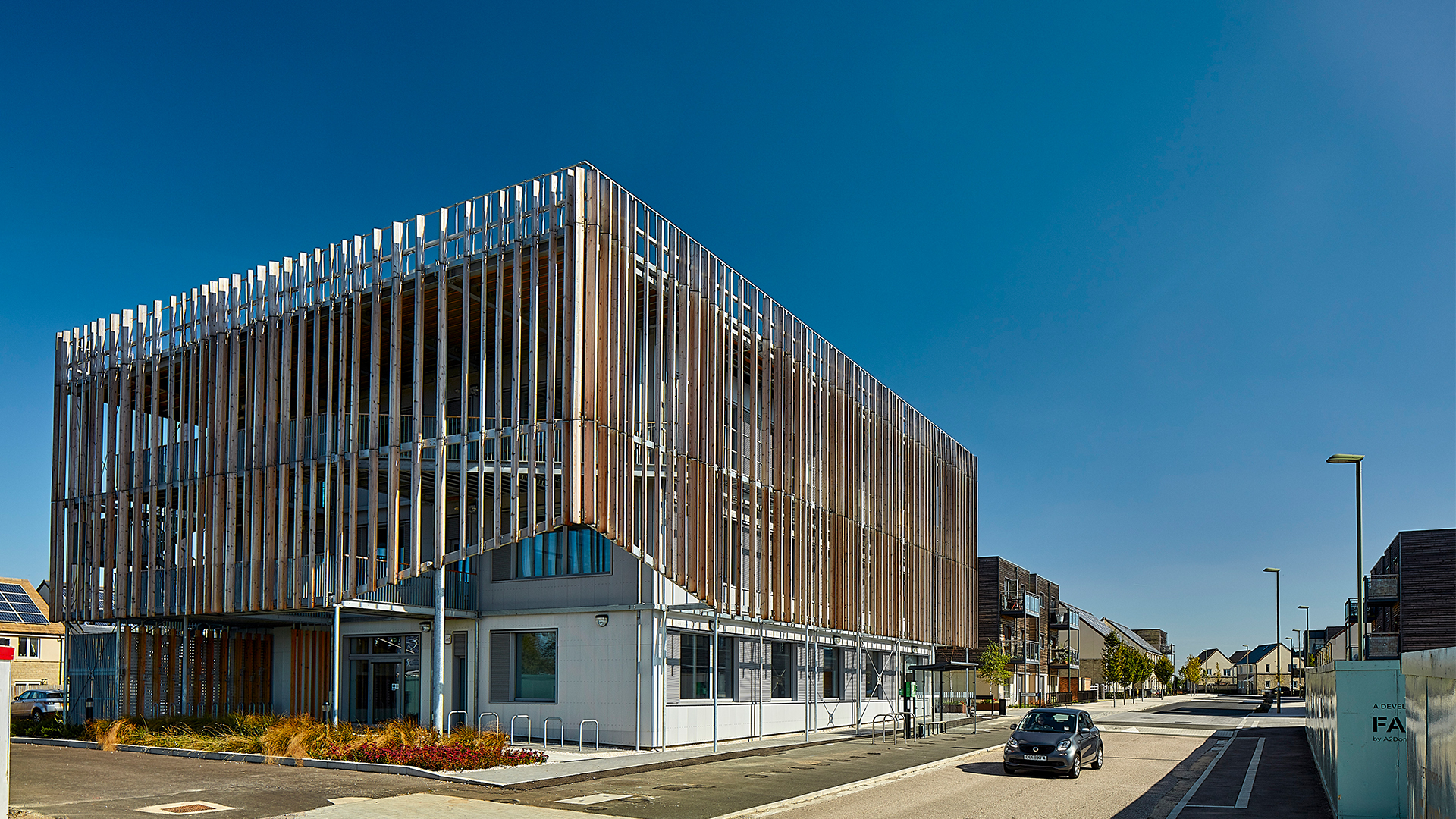 Modern office building with striking wooden facade and vertical slats under blue sky