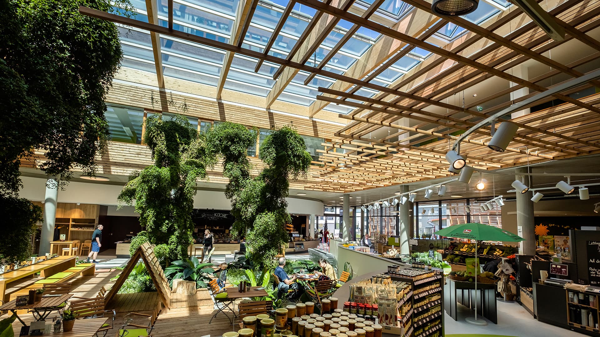 Interior of the Byodo organic food store in Mühldorf with plants, natural light, and wooden elements.