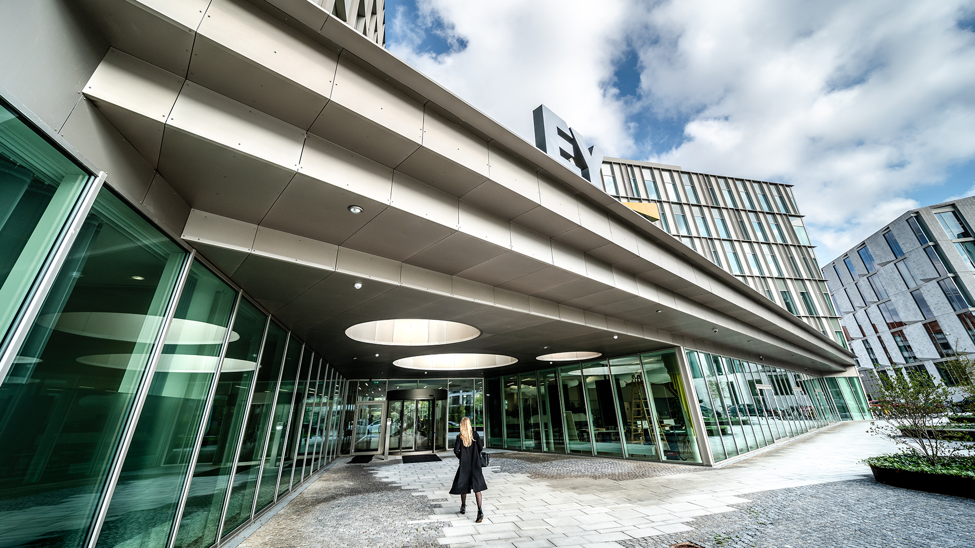 Modern EY office building with glass facade and covered entrance area