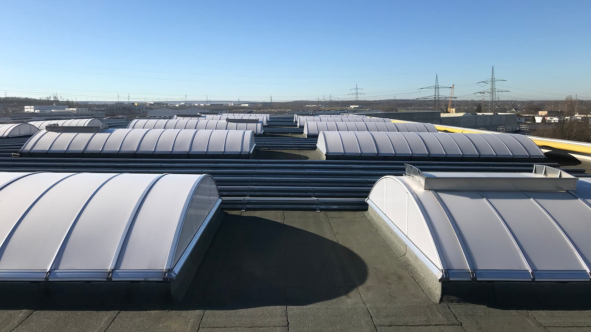 Roof of food manufacturer STUTE in Paderborn with multiple curved skylights for natural lighting.
