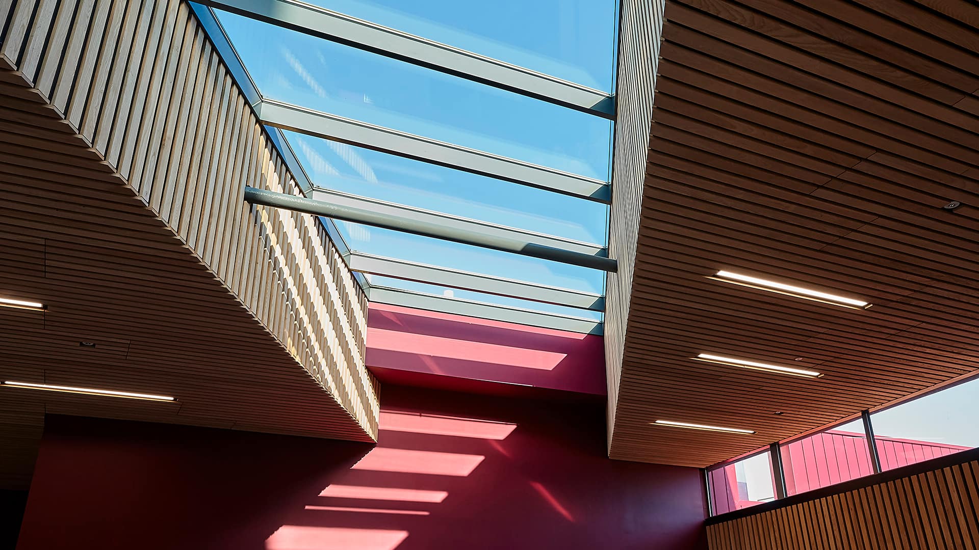 Interior view of Sheffield Hallam University featuring LAMILUX PR60 glass roof and modern wooden ceilings.