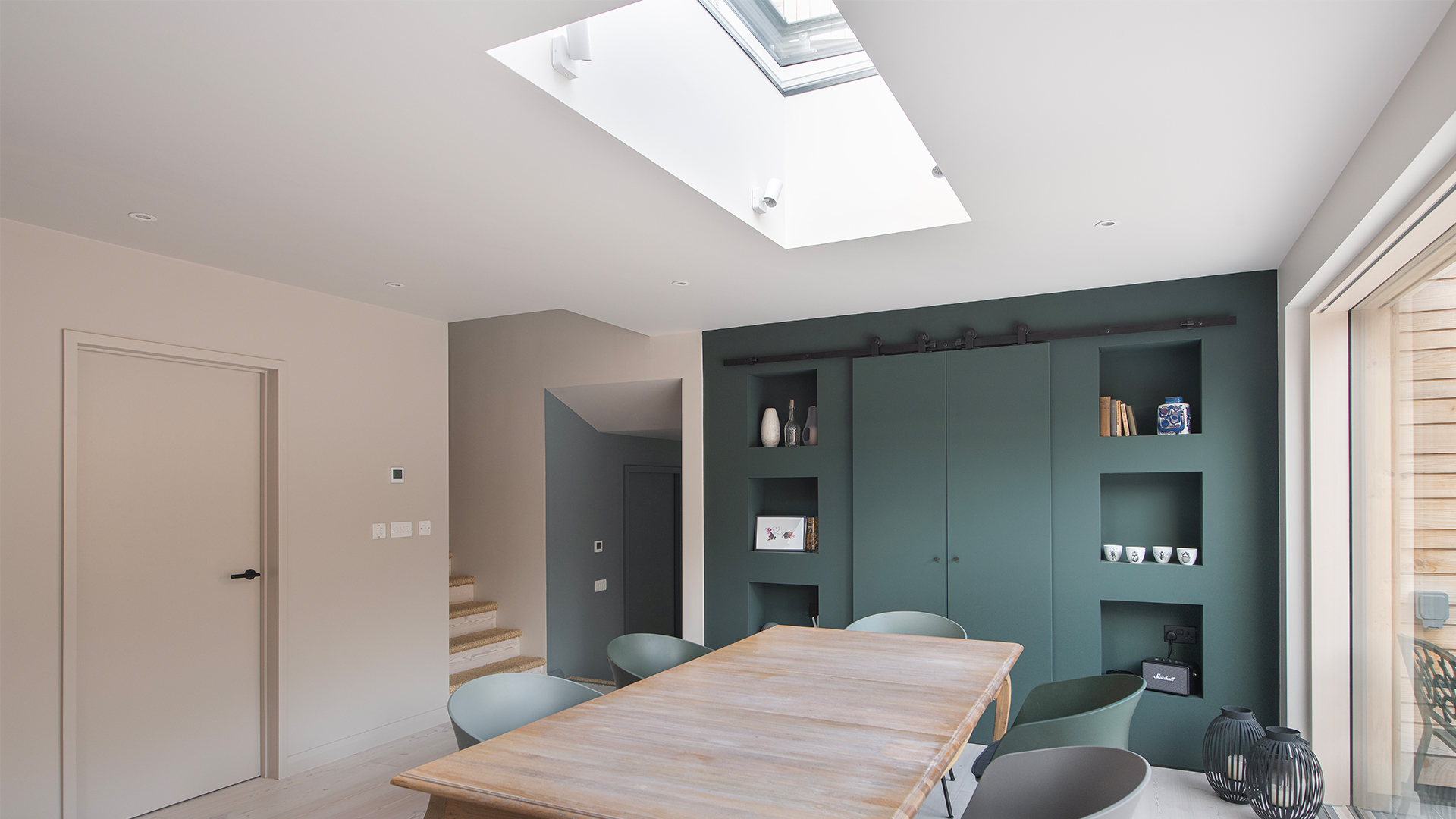 Modern living room with LAMILUX flat roof window, dining table and open kitchen