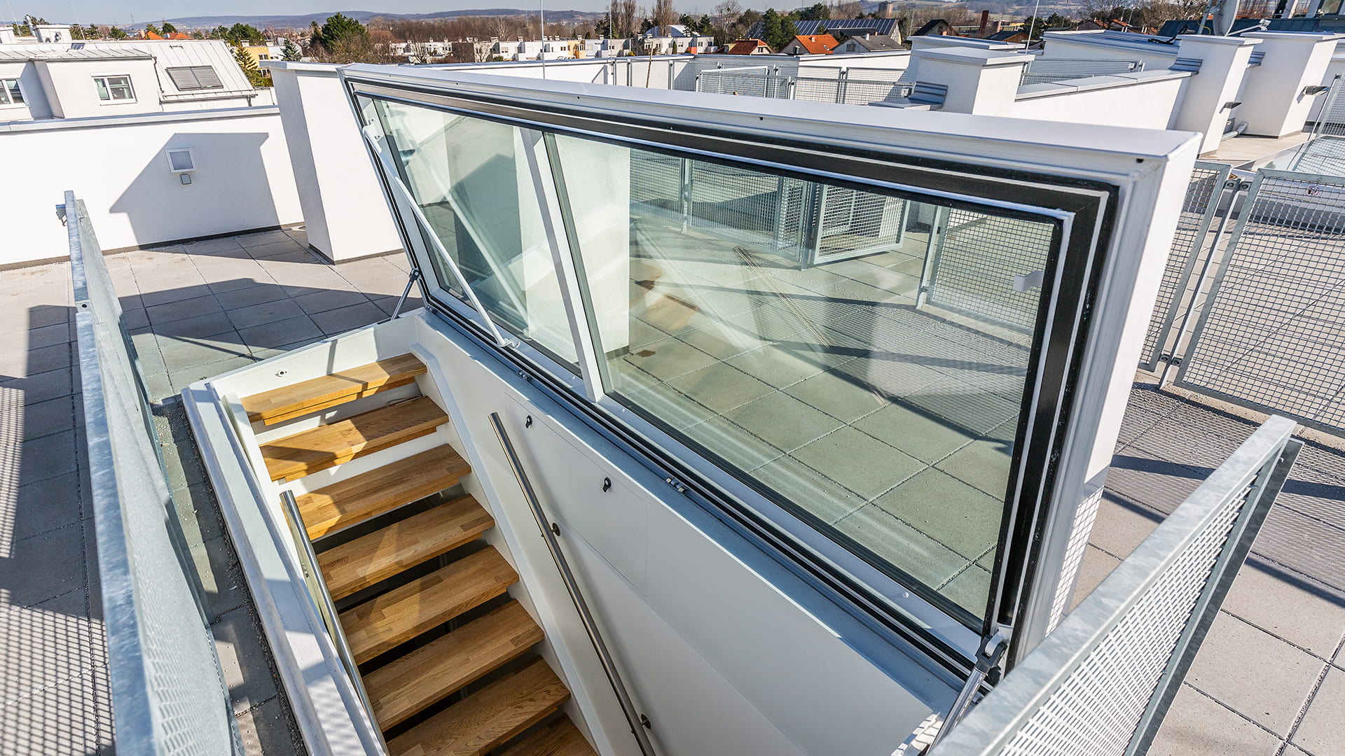 Flat roof exit by LAMILUX at a residential house in Korneuburg, featuring a modern staircase and glazing with a view of the surroundings.