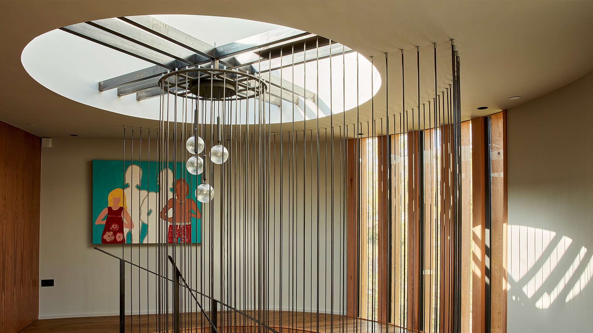 Interior with round LAMILUX flat roof window and decorative wooden slats